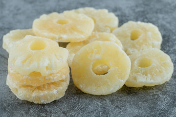 Dried pineapple slices on a marble background
