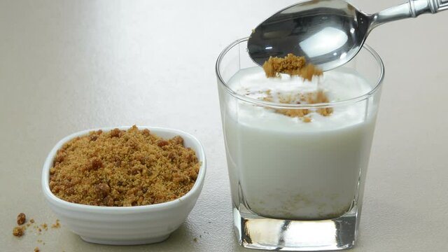 Preparing jaggery milk, mixing jaggery powder in a glass of milk.