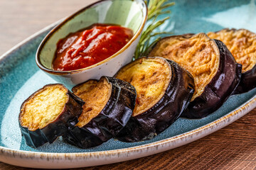 Fried eggplant and tomato sauce on a blue plate