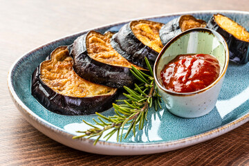 Fried eggplant and tomato sauce on a blue plate