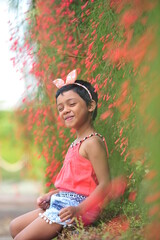 a little girl enjoying nature in a flower garden, be bright, be happy