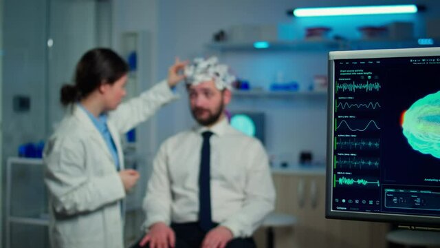 Man patient visiting professional medical researcher in neurology medicine testing brain functions with eeg headset. Doctor monitoring nervous system, descovering diagnosis of disease.