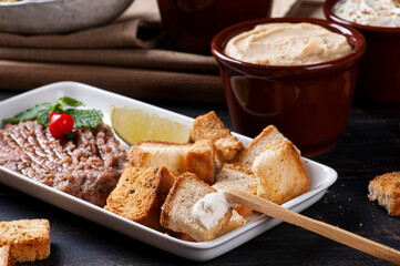 
Raw kibbeh, toast with Syrian curd, humus and babaganush in the background