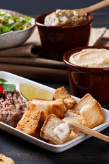 
Raw kibbeh, toast with Syrian curd, humus and babaganush in the background