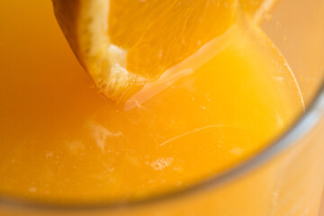 Fototapeta na wymiar Squeezed orange in a glass served with a slice of orange