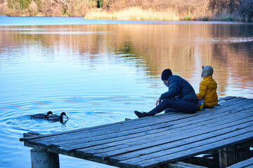 Father and son feeding the ducks