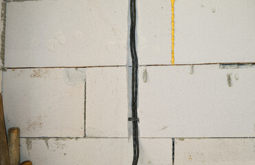 close-up - installing an electric cable (wiring) on ​​the wall, building a house