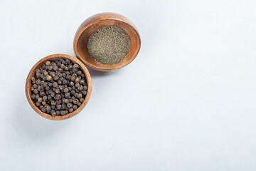 A wooden plate full of dried pepper on a white background