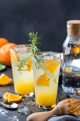Hard seltzer cocktail with orange, rosemary and bartenders accessories