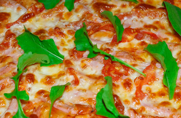 close-up - pizza with tomatoes decorated with arugula leaves