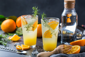Hard seltzer cocktail with orange, rosemary and bartenders accessories