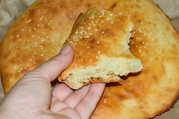girl holds in her hand a broken piece of flat cake