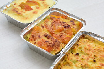 Baked chicken and mushroom cannelloni, bathed in cream in cheese sauce gratin on white wooden background