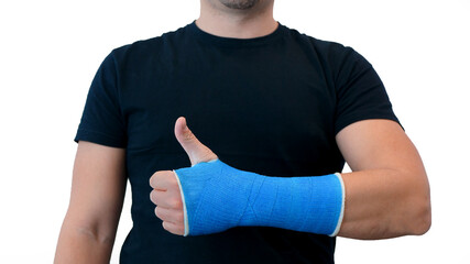 Unrecognizable man in a black T-shirt shows thumbs up and hand wrapped in a fiberglass plaster cast...
