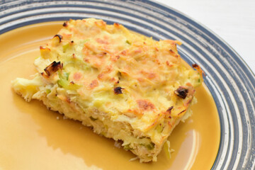 Baked chicken and mushroom cannelloni, bathed in cream in cheese sauce gratin on white wooden background