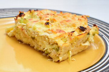 Baked chicken and mushroom cannelloni, bathed in cream in cheese sauce gratin on white wooden background