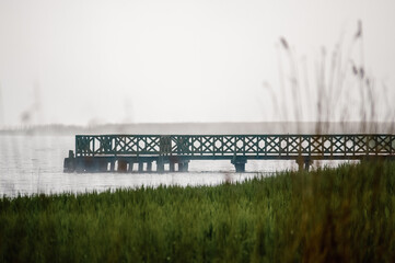 Długi drewniany pomost molo na jeziorze © Monika