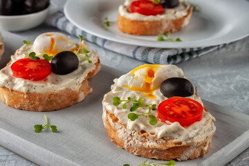 Bruschetta with tomato, olives and poached quail egg