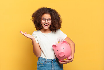 pretty afro teenager making capice or money gesture, telling you to pay your debts!. savings concept