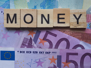 European banknotes with wooden letters. Economy concept