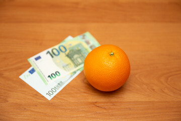 Orange and euro. The table is orange. 2 banknotes, new and old design. The 2002 and 2013 euro...