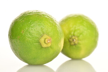 Two ripe delicious limes, close-up, on a white background.