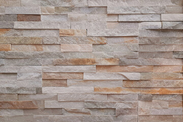 Natural shale tiles wall. Uneven masonry. Gray-pink, terracotta, orange colors. Decorative slate stone surface