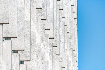 Abstract pattern closeup of contemporary modern architecture building with white vertical lines facade exterior design and blue sky