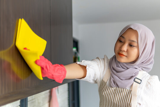 Cute Malay Woman Doing Housework By Cleaning The Kitchen