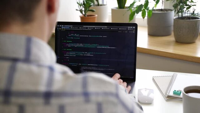 Code on the laptop screen, working environment in the office of programmers