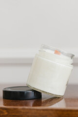 Candle, vase of flowers on a wooden table. Home and interior concept.