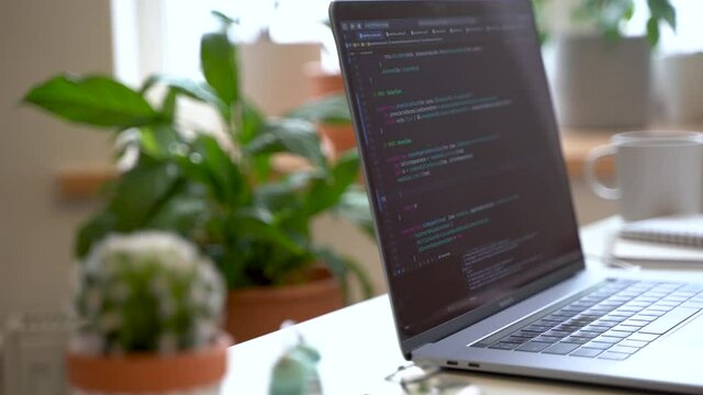 Code on the laptop screen, working environment in the office of programmers