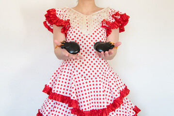Detalle de una mujer española vestida con un vestido de lunares rojos de flamenca tocando las...