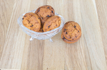 Cookies with brown chocolate in a crystal cup with wood background