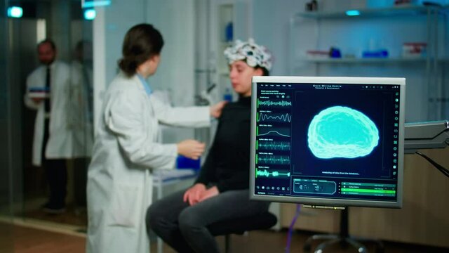 Medical researcher in neurological medicine preparing patient for examining brain functions using high tech and neurology tools for scientific research in technologically advanced lab office