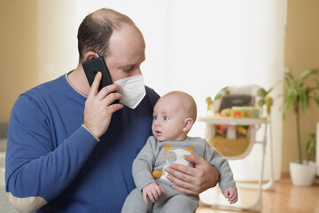 Businessman looking after newborn baby at home and teleworking