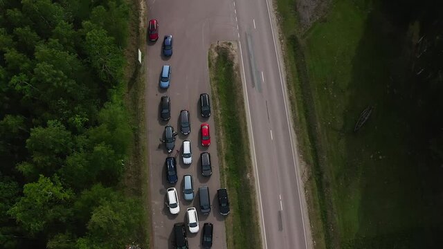 Aerial top down view of car driving on country road. Drone shot flying over fields, trees. High quality 4k footage