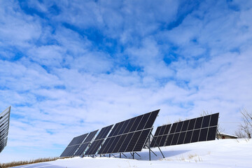 Solar panels Photovoltaic cells on a background of white and blue sky and snow. Alternative ecological solar energy.