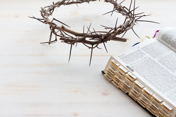 Crown of thorns with open bible on white background
