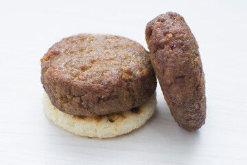 Seasoned meatloaf served with corn arepa on white wooden background