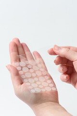 Round patches for acne and wrinkles on the hands on a white background. Acne and wrinkle patches...