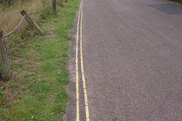 Fototapeta na wymiar Double yellow lines on a narrow country lane, meaning no parking is allowed