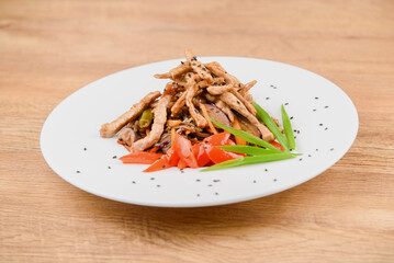 Noodles with meat and vegetables on a white plate