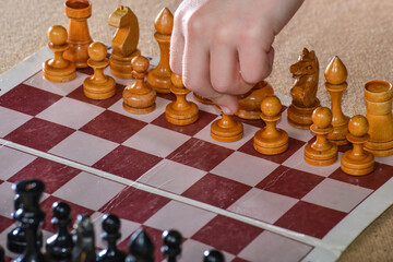 The player holds a white pawn in his hand and starts the game of
