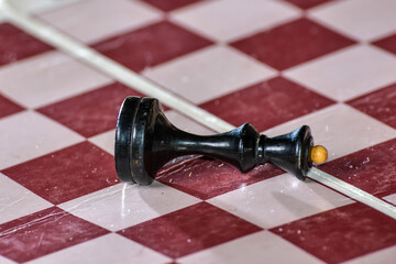 Black king lies on the chessboard, defeat and loss concept.