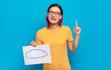 young attractive red hair woman feeling like a happy and excited genius after realizing an idea,...