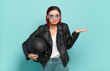 young attractive red hair woman feeling puzzled and confused, doubting, weighting or choosing...