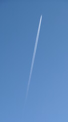 jetplane in flight with trail against clear blue sky