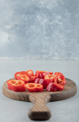 Slices of sweet red peppers on a wooden board