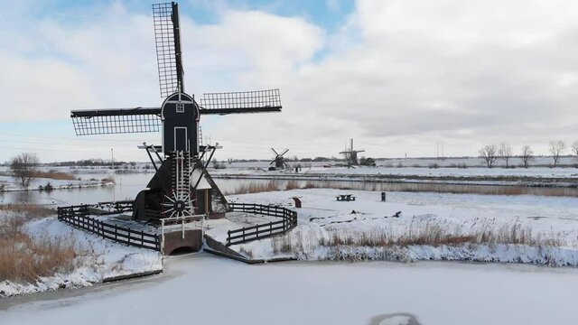Aerial: Netherlands windmills and frozen canals in winter snow